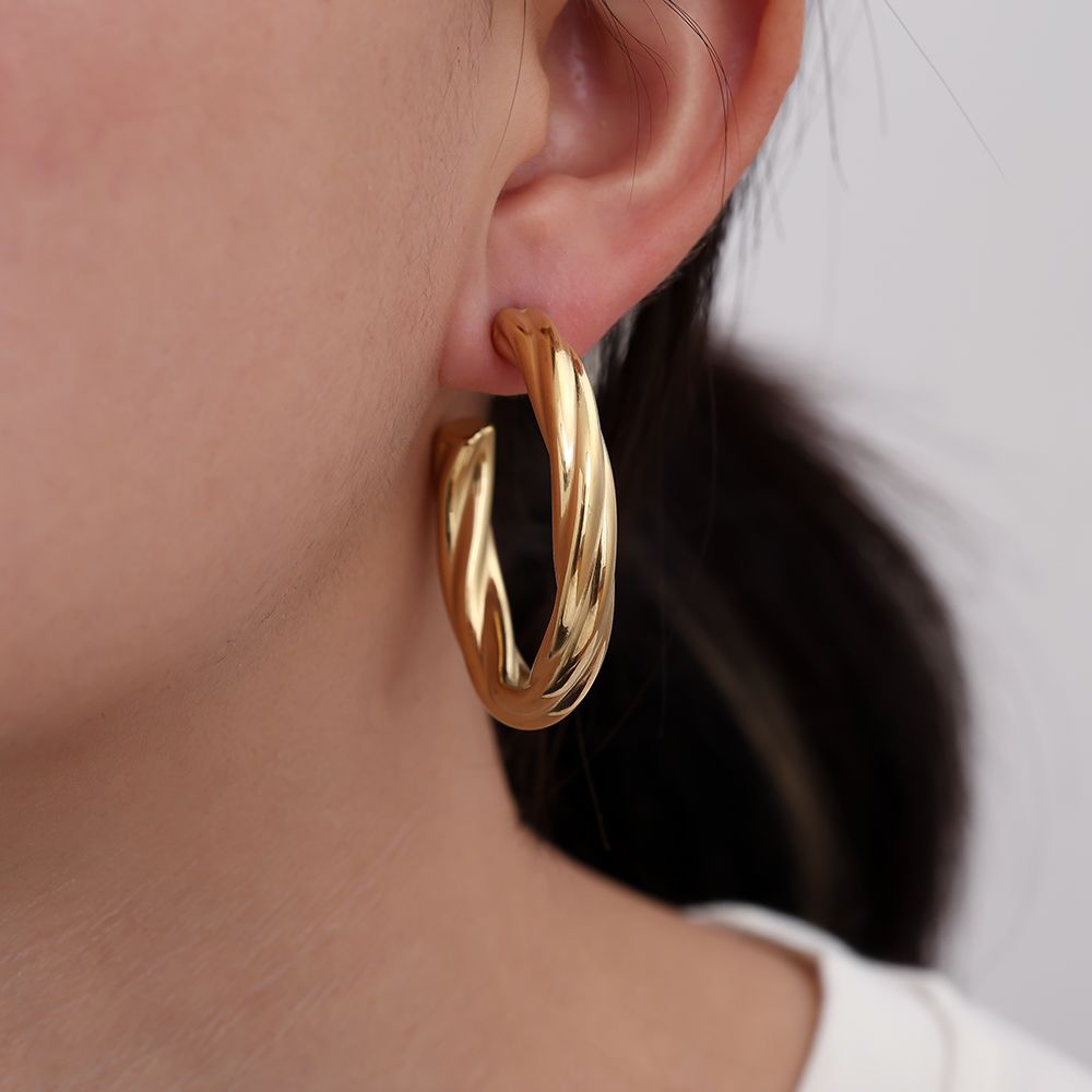 Große goldene Edelstahlcreolen mit klassisch gedrehter Form und edlem Glanz.