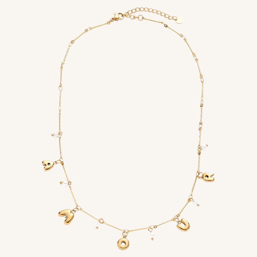 Goldene Edelstahlkette mit Amour-Schriftzug und kleiner Perle.