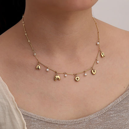 Goldene Edelstahlkette mit Amour-Schriftzug und kleiner Perle.