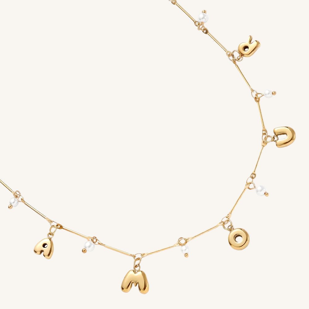 Goldene Edelstahlkette mit Amour-Schriftzug und kleiner Perle.