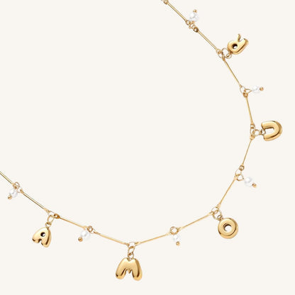 Goldene Edelstahlkette mit Amour-Schriftzug und kleiner Perle.