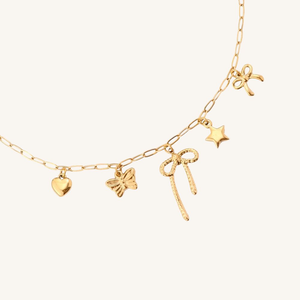 Goldene Edelstahlhalskette mit feiner Schleife und verspieltem Anhänger von Juwejé.