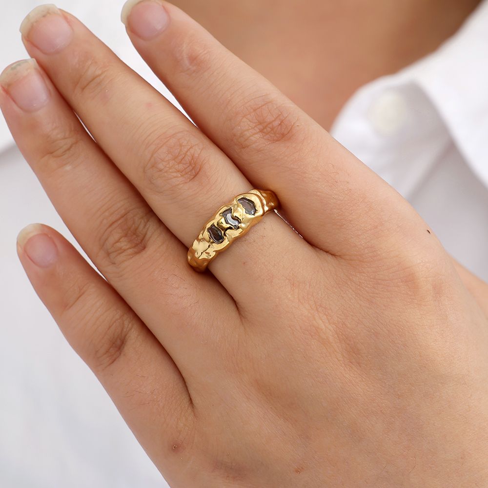 Goldener Edelstahlring mit drei funkelnden Steinen von Juwejé.