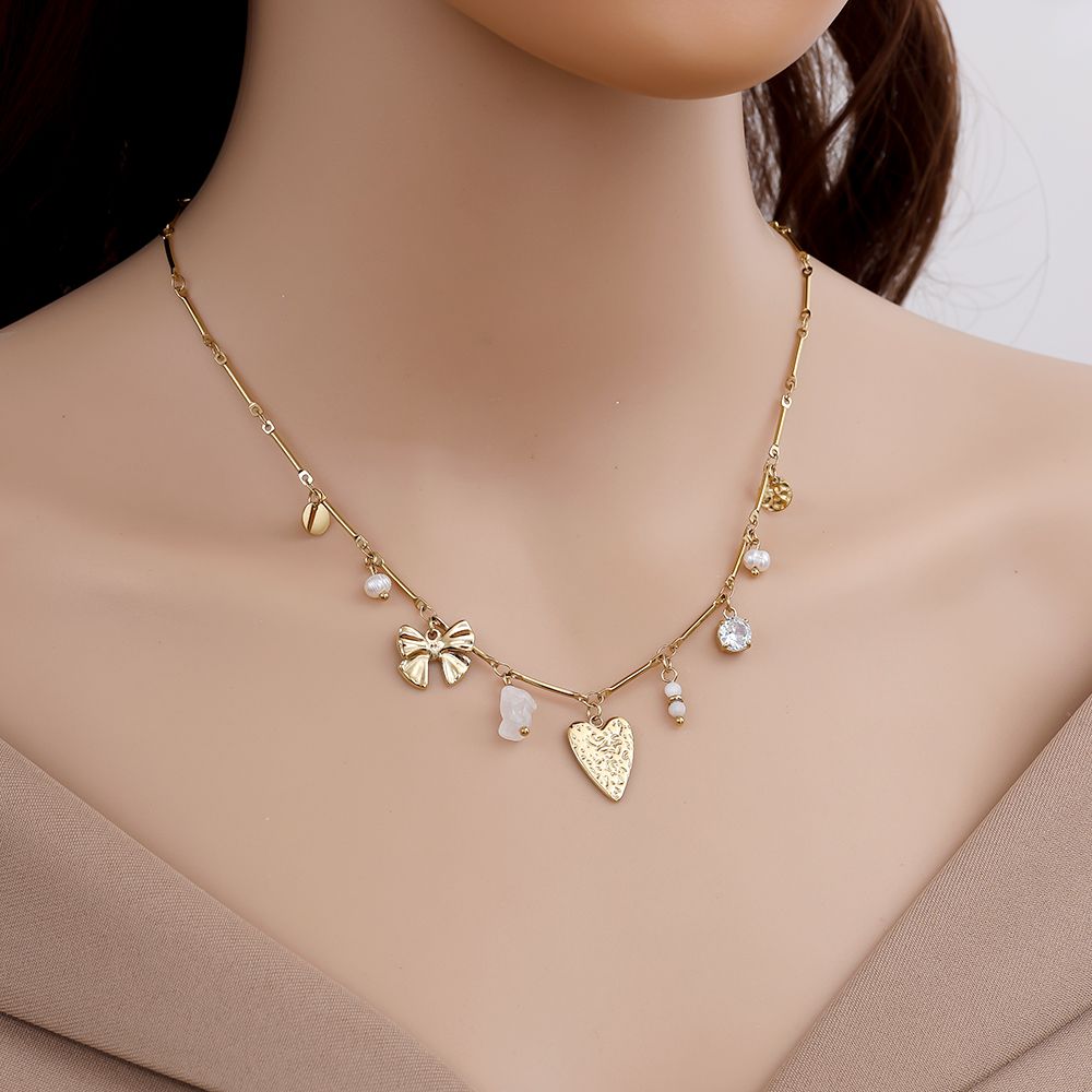 Goldene Edelstahlhalskette mit mehreren kleinen Charms und glänzendem Finish.