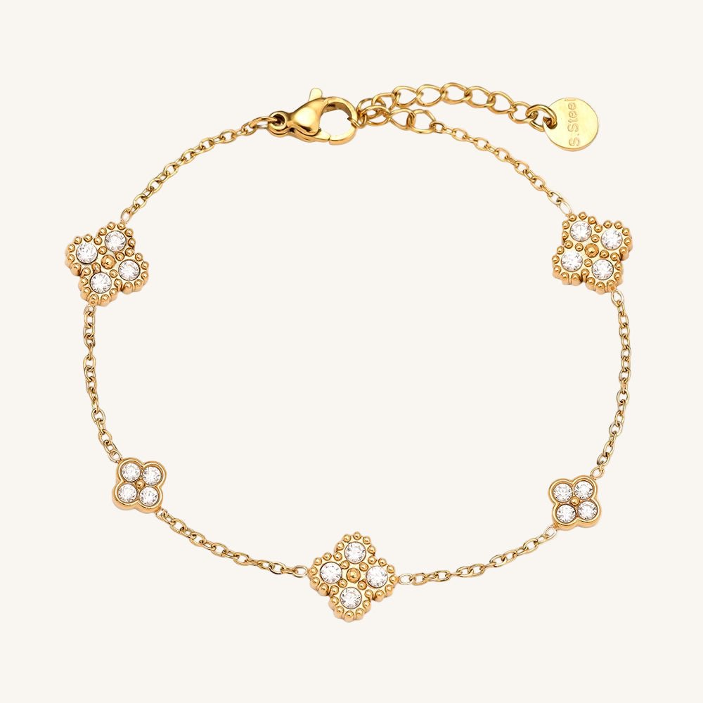 Zartes goldfarbenes Edelstahlarmband mit kleiner Blumenverzierung.