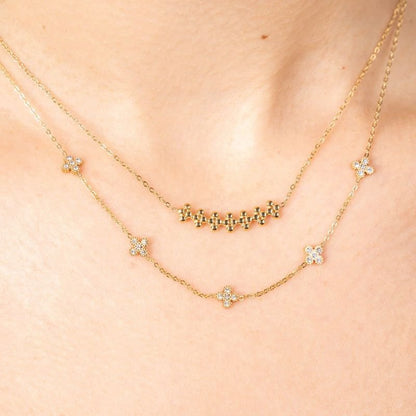 Zarte goldene Edelstahlkette mit kleiner Blumenverzierung als Glückssymbol.