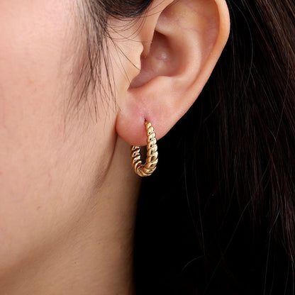 Goldene Edelstahl-Creolen mit gedrehter Struktur und poliertem Finish.